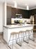 Modern kitchen with sleek cabinets, stainless steel appliances, and an inviting breakfast bar with stylish stools.
