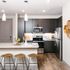 Modern kitchen with sleek dark cabinets, stainless steel appliances, and a cozy breakfast bar featuring stylish stools.