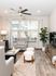Bright, modern living room featuring elegant hardwood floors, stylish furniture, and abundant natural light from large windows.