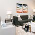 Elegant living room with modern gray sofa, stylish armchair, abstract wall art, and chic decor accents.