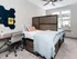 Cozy bedroom with modern decor, featuring a stylish bed, sleek desk, and ample natural light.