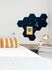 Cozy bedroom corner with a modern desk, stylish geometric wall accents, and vibrant decorative pillow.