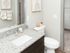 Bright and modern bathroom with elegant granite countertop, sleek fixtures, and stylish artwork for a sophisticated touch.