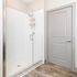 Bright modern bathroom featuring a sleek glass walk-in shower with elegant fixtures and stylish wood-look flooring.