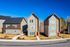 Charming modern duplexes with sleek design and large windows under a clear blue sky.