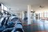 Spacious and modern fitness center with state-of-the-art equipment and large windows providing abundant natural light.