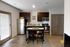 Modern kitchen with dark wood cabinets, stainless steel appliances, and a quaint island with seating, ideal for cozy dining.