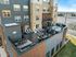Luxurious apartment balcony showcasing a modern outdoor lounge, multiple sun loungers, and an inviting hot tub, offering stunning panoramic views.