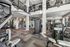 Modern fitness center with state-of-the-art equipment, vibrant artwork, and mezzanine level, perfect for an active lifestyle.