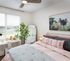 Bright and inviting bedroom with modern decor, large window, and cozy workspace, perfect for comfort and productivity.