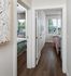 Inviting hallway leading to bright and cozy bedrooms with large windows and stylish decor.