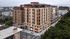 Modern multi-story apartment building with sleek design, large windows, and vibrant cityscape views.