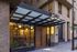 Modern apartment entrance featuring sleek glass paneling, warm lighting, and contemporary architectural design.