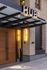 Modern apartment entrance featuring stylish glass awning and warm lighting, creating an inviting first impression.
