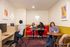 Vibrant communal workspace featuring cozy seating, colorful artwork, and engaged individuals enjoying a collaborative environment.