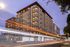 Modern urban apartment building illuminated at dusk, showcasing sleek design and vibrant city life.