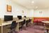 Modern, cozy workspace featuring sleek desks with computer setups, stylish chairs, and vibrant artwork on the walls, perfect for productivity and creativity.