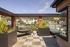 Chic rooftop deck with comfortable seating, hammock, and lush greenery offering breathtaking city views.