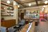 Modern lobby featuring stylish seating area with checkerboard floors, cozy lounge chairs, and warm wood accents, illuminated by chic globe lighting.