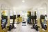 Modern fitness center with sleek exercise bikes, vibrant exercise balls, mirrored walls, and ample natural light.