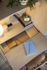 Chic workspace setup with a light wooden desk, modern lamp, clock, and notebooks, creating an inviting home office vibe.