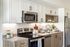 Contemporary kitchen with sleek stainless steel appliances, elegant white cabinets, and modern decor accents.