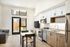 Bright, modern open-plan kitchen and living area with sleek appliances and cozy dining space leading to a private outdoor patio.