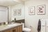 Contemporary bathroom with sleek vanity, framed art, and modern fixtures, offering a serene and stylish atmosphere.