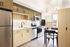 Modern kitchen showcasing sleek cabinetry, stainless steel appliances, and elegant open shelving, complemented by natural light.