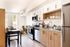 Modern apartment kitchen with sleek wood cabinetry, stainless steel appliances, and a cozy dining area.