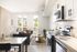 Bright and modern living space with a sleek kitchen, cozy seating area, and scenic window views, perfect for stylish living.