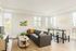 Bright and modern living room featuring a sleek sectional sofa, natural light from large windows, and elegant decor that highlights a sophisticated and inviting atmosphere.