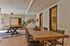 Chic communal space featuring a modern dining table, pool table, wall-mounted red bicycle, and playful decor with ample lighting.