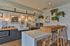 Chic modern kitchen with stylish subway tiles, warm wooden accents, industrial lighting, and lush greenery.