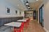 Chic modern dining area with vibrant red chairs, cozy seating, and stylish lighting, perfect for social gatherings.