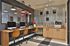 Modern and inviting workspace with sleek iMac computers, stylish brown chairs, and a chic industrial decor featuring a metallic wall accent.