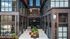 Modern urban apartment entrance with sleek architecture and lush planters, inviting ambiance.