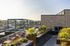 Chic urban rooftop terrace with modern seating, lush planters, and expansive city views, perfect for relaxation and gatherings.