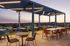 Chic outdoor terrace with modern seating and ambient lighting, perfect for relaxing or entertaining, set against a stunning sunset view.