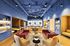 Contemporary lounge space with stylish seating, vibrant blue walls, and warm lighting, perfect for relaxation or socializing.