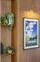 Charming wall decor with lush green plants and a framed modern art piece, enhancing the elegant wooden interior.
