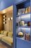 Inviting living space with elegant blue shelving, modern lighting, and a comfortable couch, perfect for relaxation and leisure.