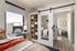 Modern bedroom featuring a cozy bed with vibrant orange accents, stylish sliding mirror doors, and abundant natural light.