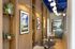 Chic modern lounge with elegant wood paneling, lush greenery, contemporary artwork, and stylish lighting fixtures creating a warm, inviting atmosphere.