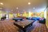 Spacious recreation area with pool tables, colorful lounge seating, and modern decor.