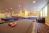 Elegant game room with pool tables, colorful seating, and contemporary art.