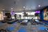 Modern fitness center with treadmills and stationary bikes overlooking a basketball court.