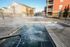 Relaxing hot tub area with warm bubbling water and apartment buildings in the background.