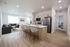 Modern open-concept kitchen and living area with sleek stainless steel appliances, cozy seating, and elegant hardwood flooring.