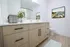 Sleek bathroom design featuring modern light wood cabinetry, elegant countertop decor, and a vibrant landscape painting.
